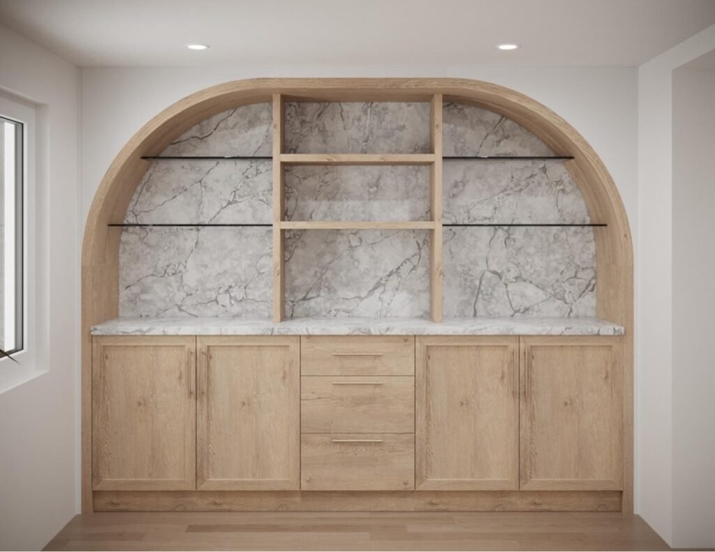 Arched oak built-in cabinets with marble backing and glass shelves by T.H. Cabinets