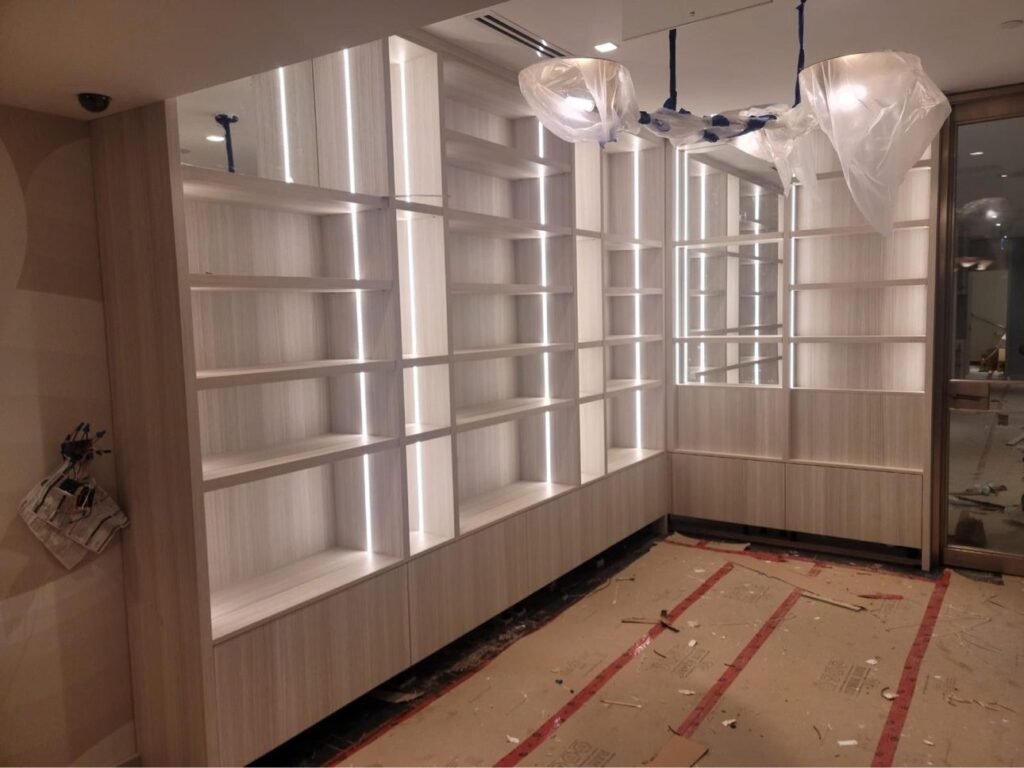 Illuminated salon shelving during installation by T.H. Cabinets