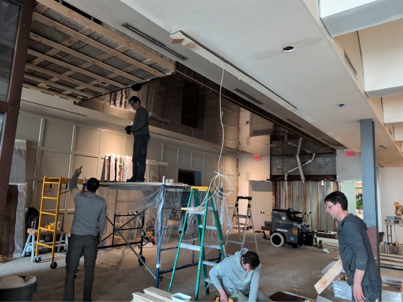 Installer on scaffold fitting panelled millwork in a restaurant