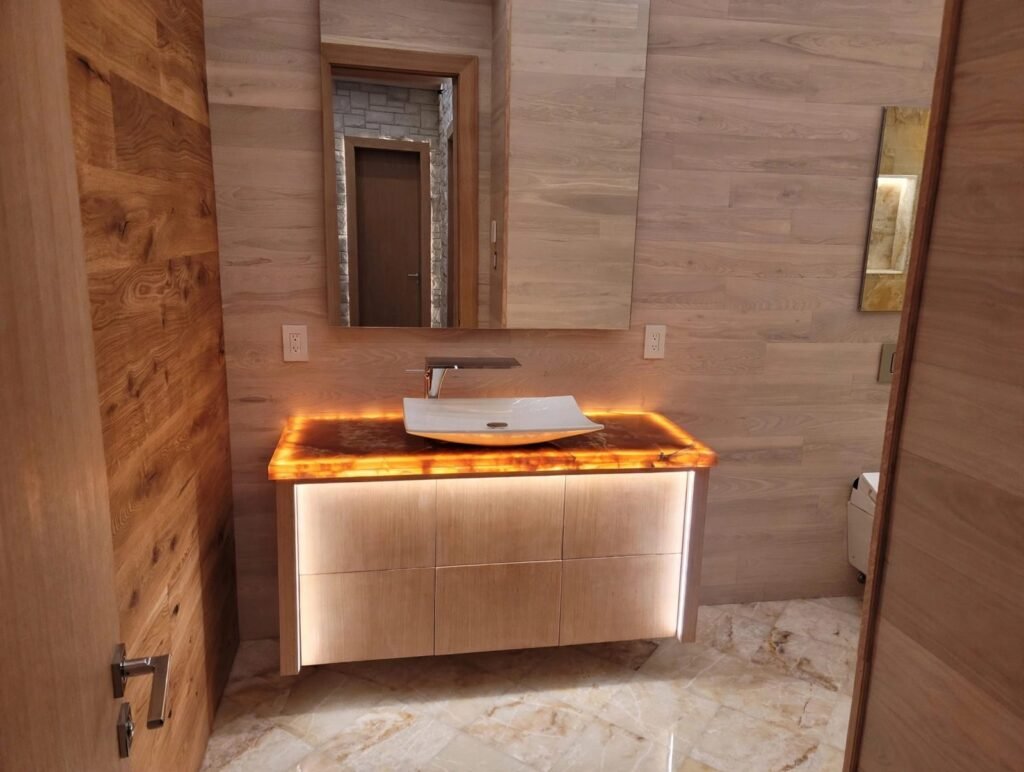 Floating bathroom vanity with backlit onyx countertop by T.H. Cabinets