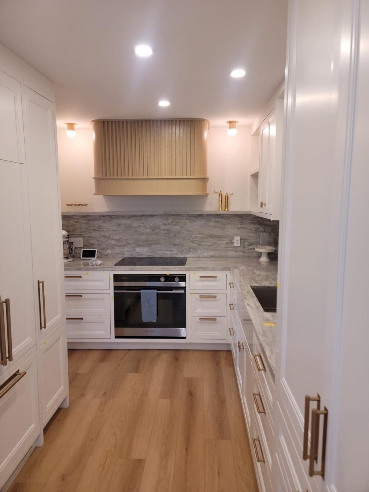 White shaker kitchen with fluted wood range hood