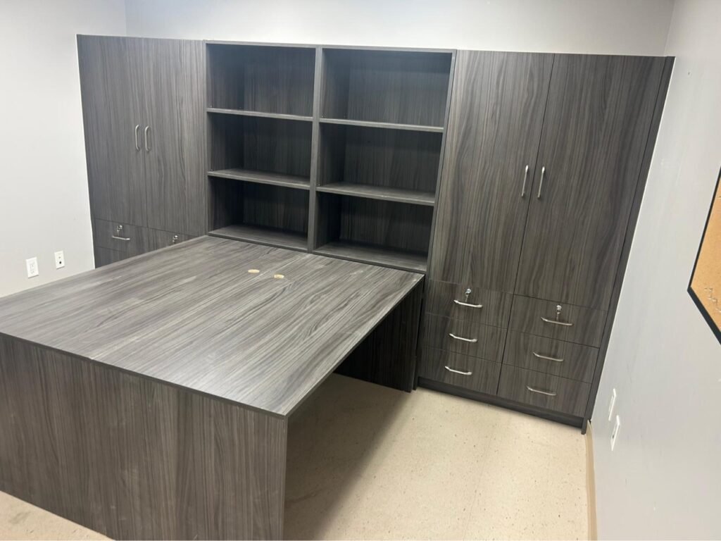 Custom home office with grey woodgrain built-in desk and storage wall by T.H. Cabinets