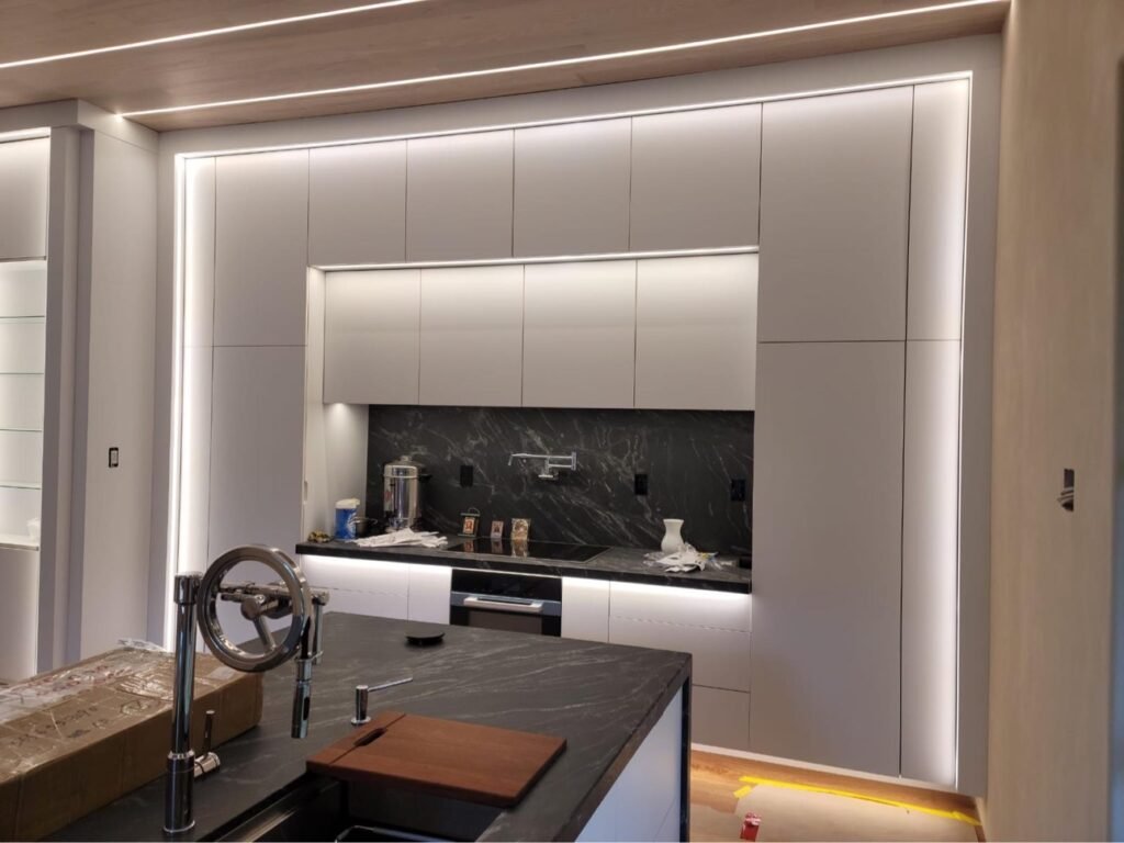 Modern white kitchen cabinetry with LED feature lighting, T.H. Cabinets project