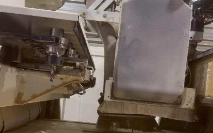 CNC machine carving cabinet door panels in the T.H. Cabinets workshop