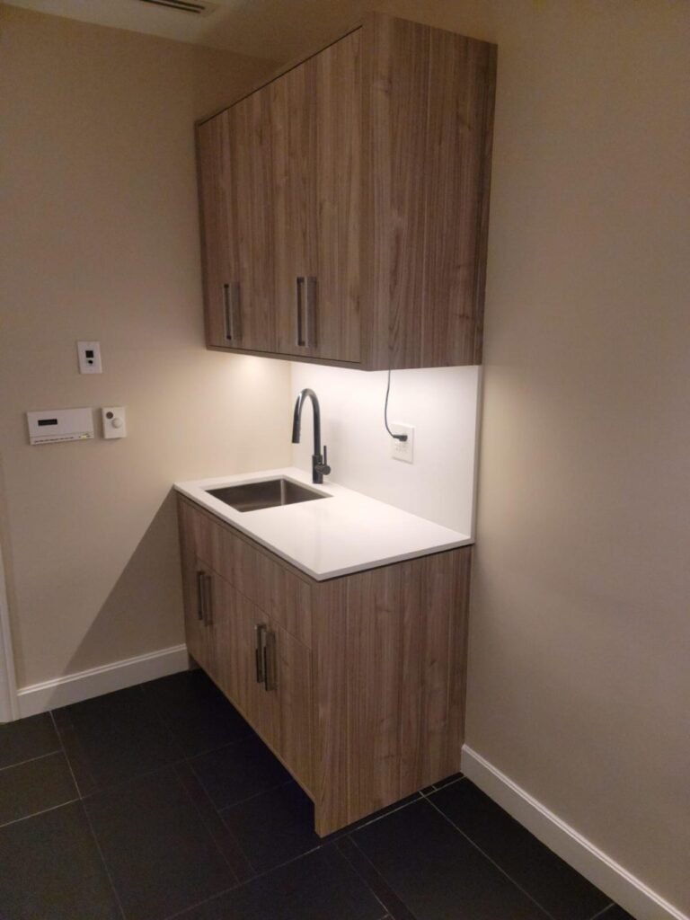 Walnut wet bar built-in cabinetry with under-cabinet lighting by T.H. Cabinets
