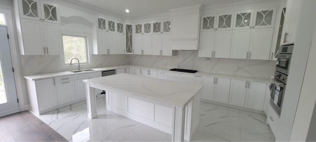 White kitchen cabinets with mullion glass-front uppers by T.H. Cabinets