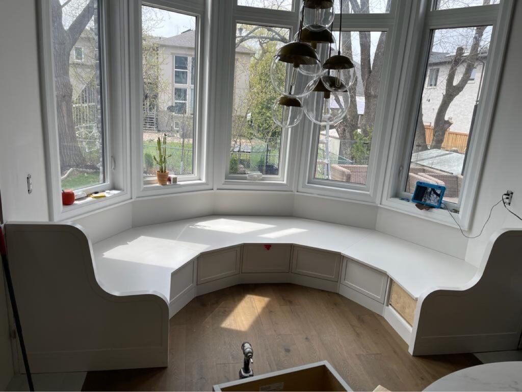 Custom curved window banquette with built-in storage by T.H. Cabinets