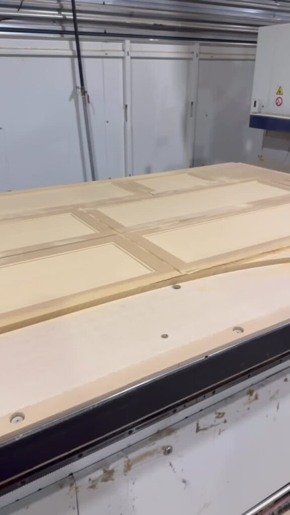 Freshly cut cabinet door panels nested on the CNC bed