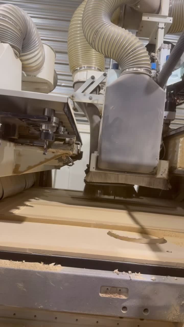 CNC spindle carving a cabinet door panel in the T.H. Cabinets workshop